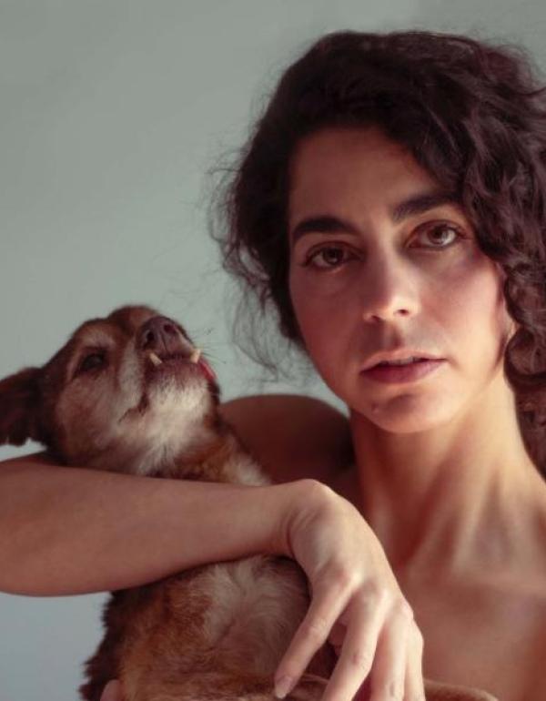 Director Headshot - curly haired woman holding dog
