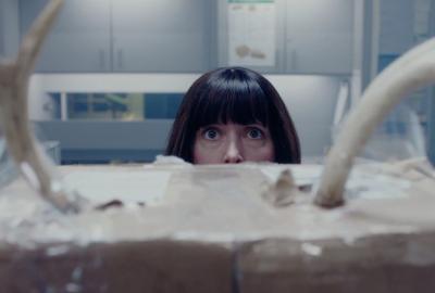 A woman hiding looks up in fear