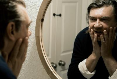 A man looks into a mirror in fear