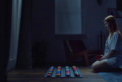 A woman sits in front of dog communication toy