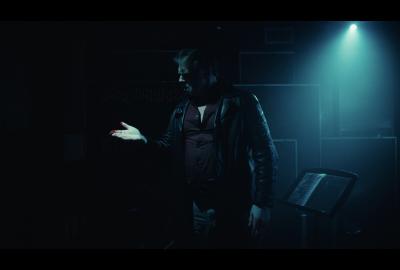 A man in a dark room looks at something