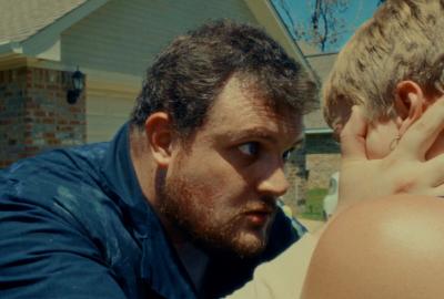 A man holds a woman's face close to his