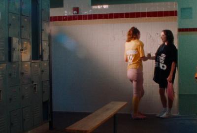 Two women shake hands in locker room