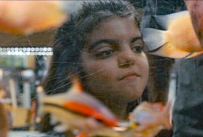 A young girl sits at a table in a cafe