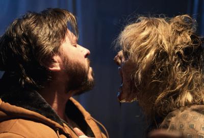 Man shrinks backwards from a chained up Undead Specimen.