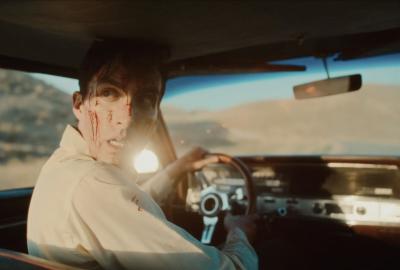 Anxious man driving, covered in blood