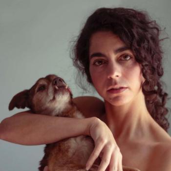 Director Headshot - curly haired woman holding dog